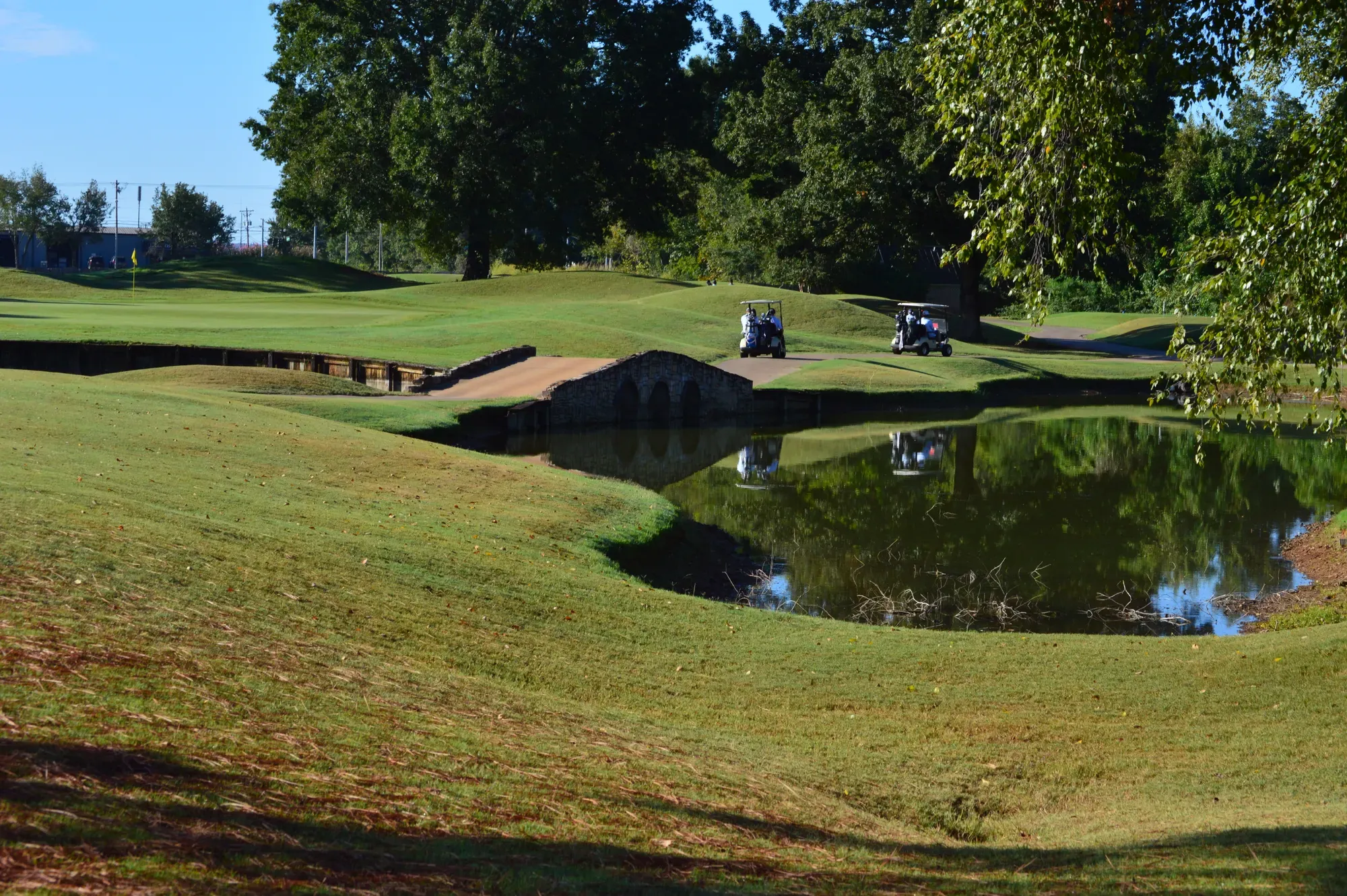 A four-man team in light blue shirts standing behind two hole-sponsor signs on the tee